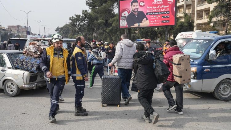 Sírios carregando seus pertences fogem de um bairro em Aleppo, no norte da Síria, em 8 de janeiro de 2026.