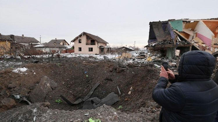 Pessoas inspecionam a cratera de um proj&eacute;til no local de um ataque russo perto de um pr&eacute;dio residencial em Putrivka, regi&atilde;o de Kiev, Ucr&acirc;nia, em 22 de fevereiro de 2026, em meio &agrave; invas&atilde;o russa. Pelo menos uma pessoa morreu e outras oito foram resgatadas dos escombros, incluindo uma crian&ccedil;a, ap&oacute;s um ataque combinado russo com drones e m&iacute;sseis durante a noite contra a capital ucraniana e distritos vizinhos, de acordo com o Servi&ccedil;o Estatal de Emerg&ecirc;ncia da Ucr&acirc;nia. EPA/STRINGER