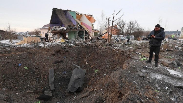 Pessoas inspecionam a cratera de um proj&eacute;til no local de um ataque russo perto de um pr&eacute;dio residencial em Putrivka, regi&atilde;o de Kiev, Ucr&acirc;nia, em 22 de fevereiro de 2026, em meio &agrave; invas&atilde;o russa. Pelo menos uma pessoa morreu e outras oito foram resgatadas dos escombros, incluindo uma crian&ccedil;a, ap&oacute;s um ataque combinado russo com drones e m&iacute;sseis durante a noite contra a capital ucraniana e distritos vizinhos, de acordo com o Servi&ccedil;o Estatal de Emerg&ecirc;ncia da Ucr&acirc;nia. EPA/STRINGER