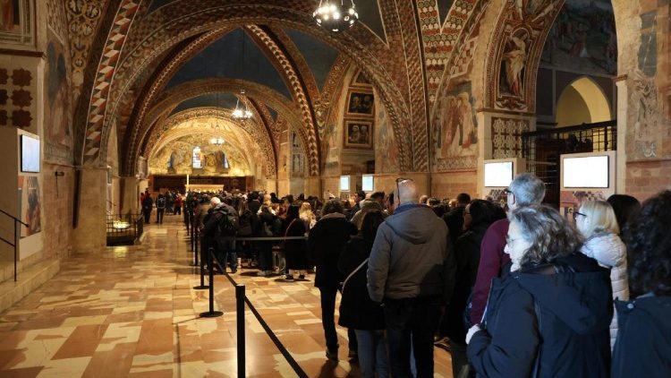 Pellegrini in fila nella basilica inferiore per rendere omaggio alle spoglie di san Francesco (foto Ansa)