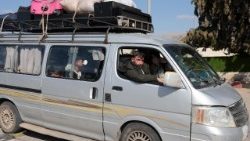 Profughi a bordo di un minivan al confine tra Libano e Siria