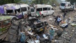 Algunas personas observan los vehículos destruidos tras un atentado perpetrado en la Carretera Panamericana, en Cajibio (Colombia)