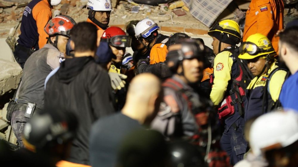 Equipes de emergência buscam vítimas após dois fortes terremotos atingirem a costa caribenha da Venezuela, perto de Caracas, em 25 de junho de 2026. Pelo menos 32 pessoas morreram e 700 ficaram feridas após dois terremotos consecutivos atingirem o centro-norte da Venezuela em rápida sucessão, provocando o desabamento de prédios, rachaduras em fachadas e levando à declaração de estado de emergência nacional, segundo a presidente interina da Venezuela, Delcy Rodríguez. EPA/Ronald Peña R