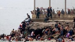 Migrantes marroquíes y argelinos entran en Ceuta por mar tras cruzar la frontera a nado.