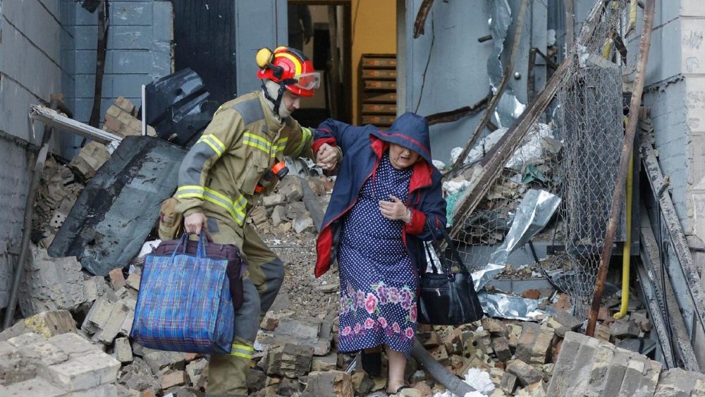Um socorrista ajuda uma moradora local no local de um ataque com mísseis russos a uma área residencial em Kiev, Ucrânia, em 20 de agosto de 2026, em meio à invasão russa. Pelo menos 14 pessoas morreram e mais de 40 ficaram feridas em um ataque combinado russo em larga escala, realizado durante a noite com drones e mísseis de diferentes tipos, contra Kiev e a região, segundo o Serviço Estatal de Emergência da Ucrânia (SES). EPA/SERGEY DOLZHENKO