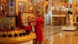 Monge budista toca as pegadas de Budha durante a celebração do Vesak em Bankok (2021)
