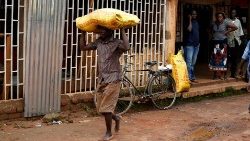 Ein malawischer Arbeiter trägt einen Sack Dünger