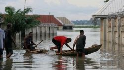 Flood-affected people enter a canoe on a flooded street close to the bank of Benue River in Makurdi