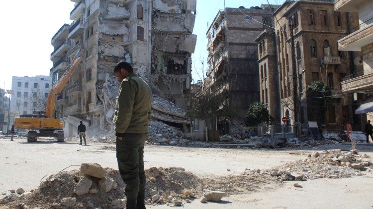 시리아 알레포 지역의 강진으로 무너진 건물 앞에 선 한 남자