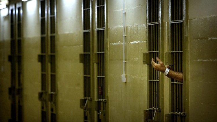 FILE PHOTO: An Iraqi detainee gestures toward U.S. soldiers through bars of his cell at Abu Ghraib prison