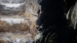 A Ukrainian service member smokes in a shelter at a front line near the city of Bakhmut