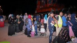 सूडानी और अन्य राष्ट्रीयताओं के लोग पोर्ट सूडान में एक जहाज पर चढ़ने की तैयारी में