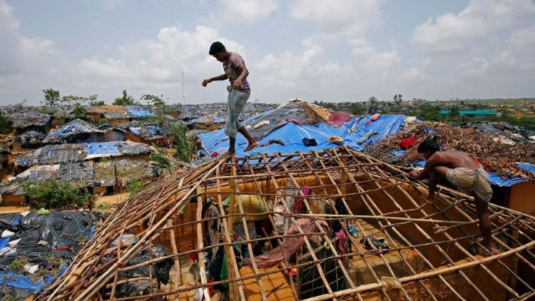 चक्रवात से नष्ट हो जाने के बाद रोहिंग्या शरणार्थी अपने शरणार्थी शिविर में अपने घरों का पुनर्निर्माण कर रहे हैं