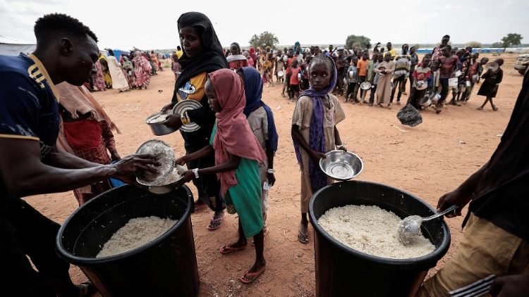 Sudaneses recebem porções de arroz de voluntários da Cruz Vermelha