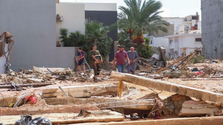 Watu wakiwa wanatembea kwenye mahofu mara baada ya kimbunga na mvua kali huko Derna nchini Libya.