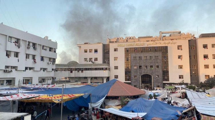 Smoke rises as displaced Palestinians take shelter at Al Shifa hospital, amid the ongoing conflict between Hamas and Israel, in Gaza City