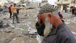 Palestinians inspect the site of an Israeli strike on a house belonging to Fojo family, in Rafah