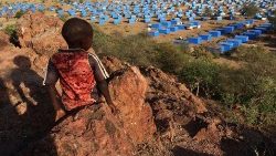 A boy overlooks a refugee camp near the Chad-Sudan border
