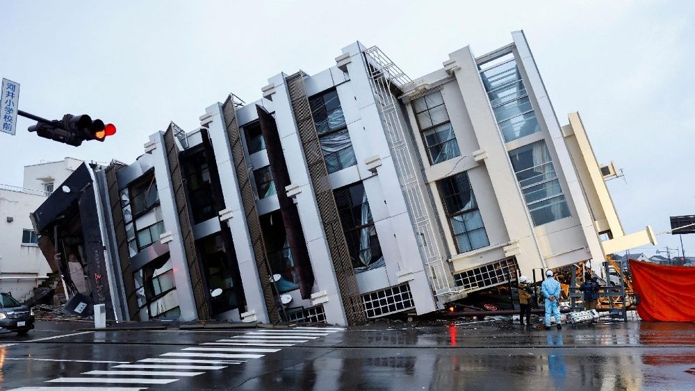 Pessoas perto de um prédio desabado após um terremoto, em Wajima, Japão, 3 de janeiro de 2024. REUTERS/Kim Kyung-Hoon