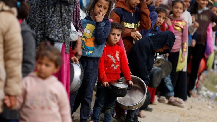 Children wait to receive food amid shortages of food supplies.