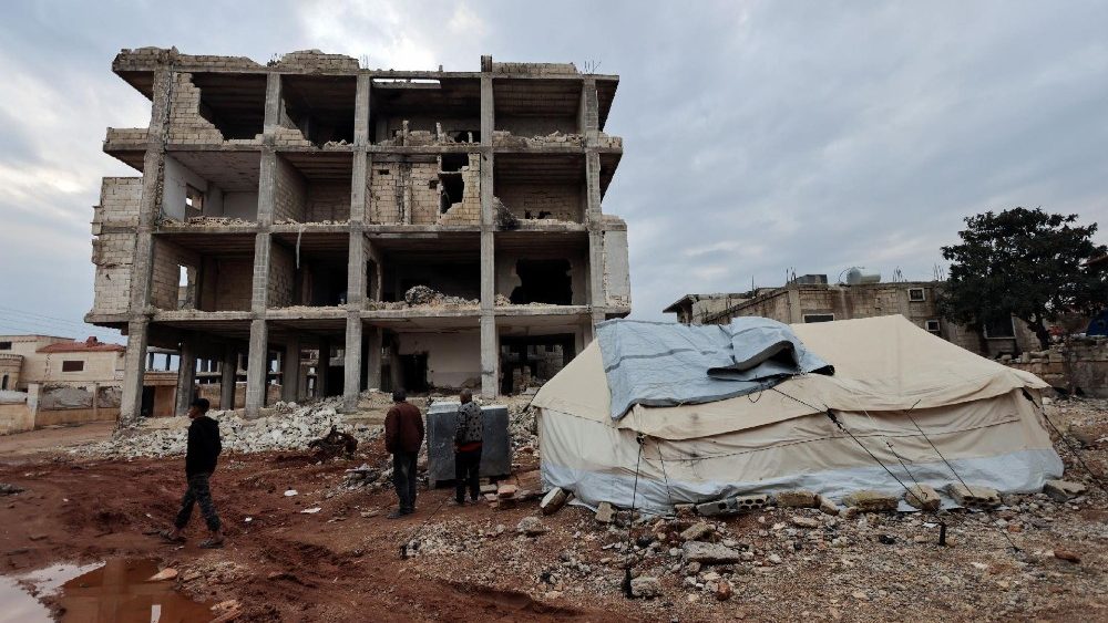 Homens perto de uma tenda para sobreviventes do terremoto erguida fora de um prédio danificado que foi atingido por um terremoto mortal em 6 de fevereiro de 2023, quase um ano após a ocorrência do terremoto, na cidade controlada pelos rebeldes de Jandaris, Síria, 25 de janeiro de 2024. REUTERS /Khalil Ashawi
