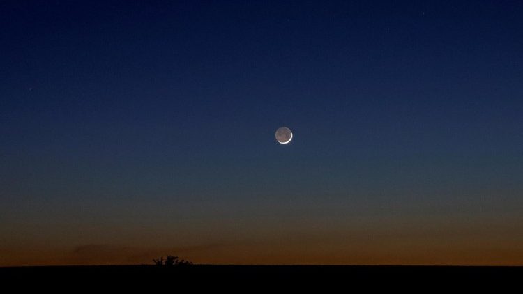 Neumond über Rauchschleiern durch Beschuss in der Region Donetzk