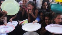 Palästinensische Kinder versammeln sich im nördlichen Gazastreifen, um angesichts des anhaltenden Konflikts zwischen Israel und der Hamas von einer Wohltätigkeitsküche gekochtes Essen zu erhalten.