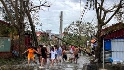 People in Vietnam clearing debris in the aftermath of floods caused by Typhoon Yagi