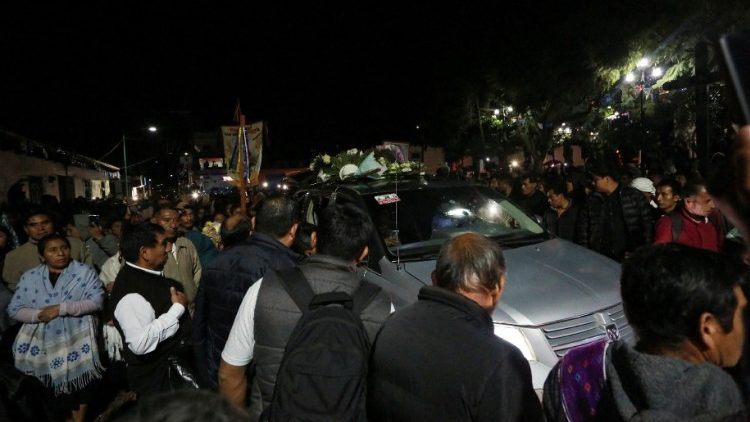 Menschen umringen das Auto, in dem der Sarg des prominenten Priesters transportiert wird