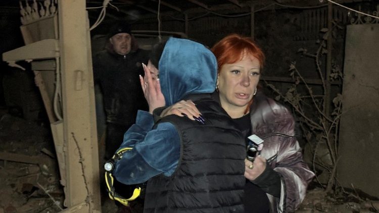 Reação de ucranianas ao lado da casa destruída de seus vizinhos que foram mortos por um ataque de míssil russo, em meio ao ataque da Rússia à Ucrânia, em Kharkiv, Ucrânia, em 29 de outubro de 2024. REUTERS/Vitalii Hnidyi