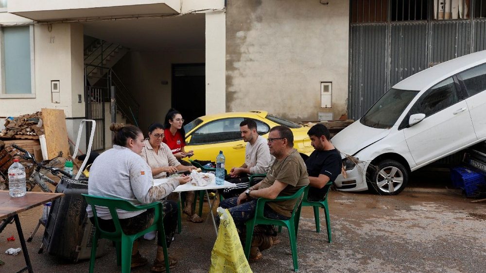 Família Meseguer Serrano se reúne ao lado de seus pertences e carros danificados após chuvas torrenciais causarem inundações em Guadassuar, região de Valência, Espanha, 30 de outubro de 2024. REUTERS/Eva Manez