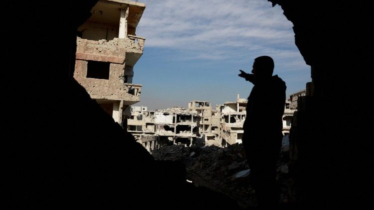 A person gestures to the al-Yarmouk Palestinian refugee camp following the fall of the Assad regime