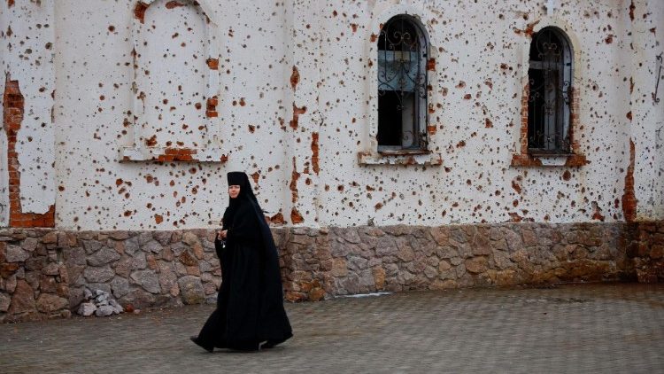 Uma freira caminha do lado de fora do Mosteiro de St. Iveron, que foi fortemente danificado por artilharia e tiros durante as batalhas pelo aeroporto local, enquanto fiéis participam do culto de Natal ortodoxo durante o conflito Rússia-Ucrânia em Donetsk, Ucrânia controlada pela Rússia, em 7 de janeiro de 2025. REUTERS/Alexander Ermochenko
