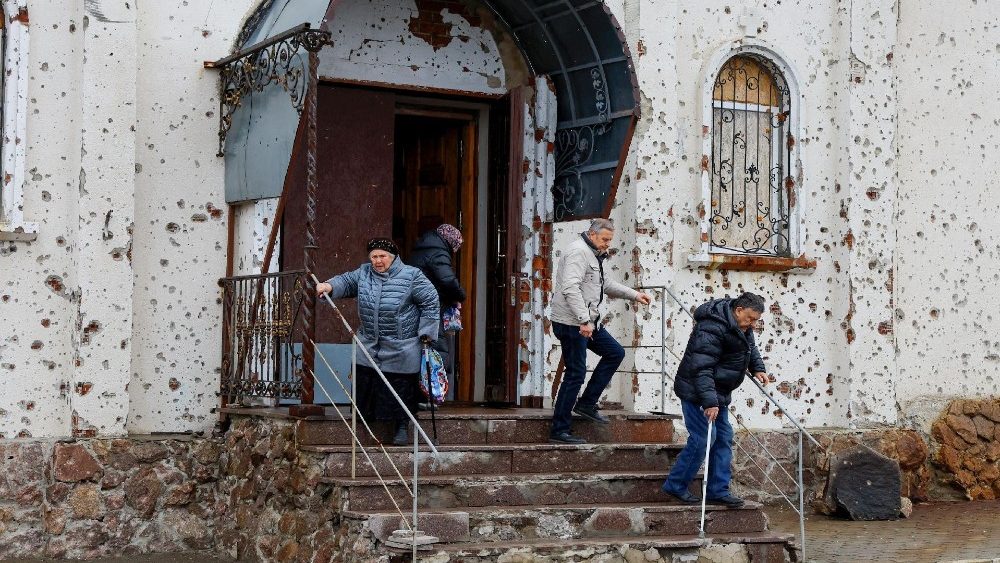 Fiéis saem do Mosteiro de Santo Iveron, que foi severamente danificado por tiros de artilharia e armas de fogo durante os combates pelo aeroporto local, após a missa ortodoxa de Natal no contexto do conflito entre Rússia e Ucrânia em Donetsk, Ucrânia controlada pela Rússia, 7 de janeiro de 2025. REUTERS/Alexander Ermochenko