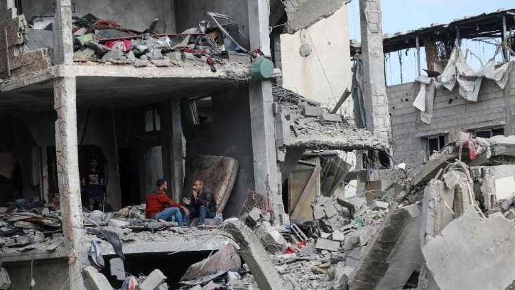 Scenes of destruction in Gaza: two men sit in a destroyed house