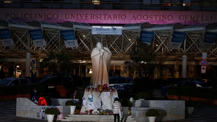 ഫ്രാൻസീസ് പാപ്പാ ചികിത്സയിൽ കഴിയുന്ന ജെമേല്ലി ആശുപത്രിയുടെ ഒരു നിശാദൃശ്യം, വിശുദ്ധ രണ്ടാം ജോൺപോൾ മാർപ്പാപ്പായുടെ സ്വരൂപത്തിനു മുന്നിൽ പ്രാർത്ഥനയോടെ