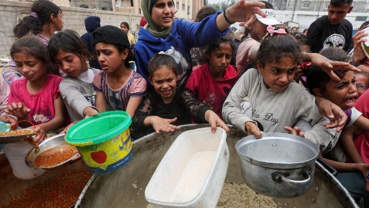 नुसेरात में चारिटी किचन से खाना ले जाते फिलिस्तीनी