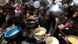 Палестинци чакат да получат храна, приготвена от благотворителна кухня в Джабалия, в северната част на ивицата Газа.