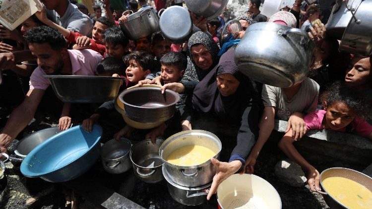 Палестинци чакат да получат храна, приготвена от благотворителна кухня в Джабалия, в северната част на ивицата Газа.