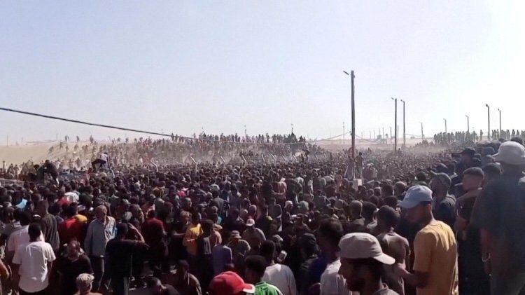 Folla di civili palestinesi presso il centro di distribuzione di aiuti umanitari a Rafah