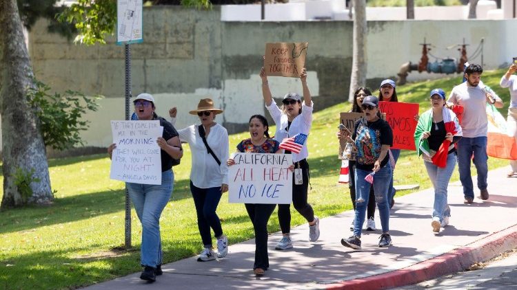 People march alongside riders from Connecting Compton who ride in a 'cabalgata' for human rights following multiple detentions by Immigration and Customs Enforcement (ICE), in the Los Angeles County city of Compton, California