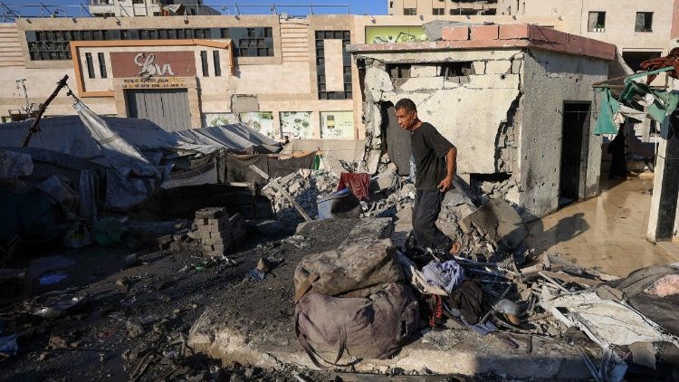 Un palestinese ispeziona i danni sul luogo di un attacco israeliano notturno su una tenda che ospitava sfollati, a Gaza City, il 24 luglio 2025