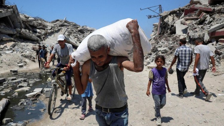 Palestinians carry aid supplies that entered Gaza through Israel, in Beit Lahia