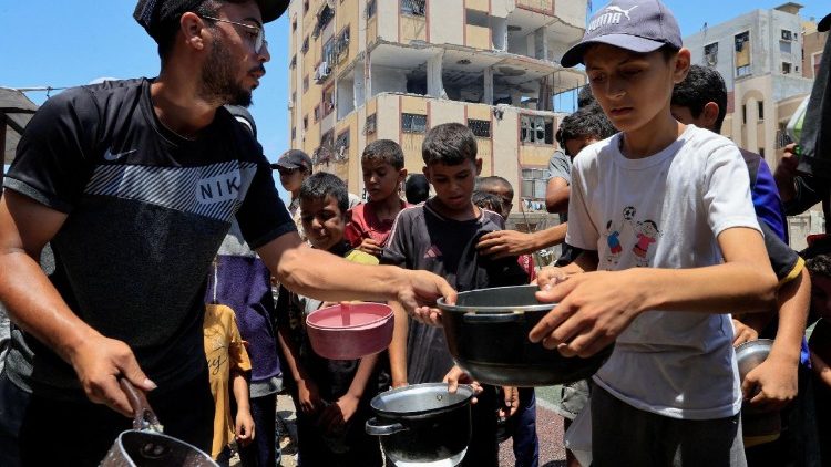 FILE PHOTO: Palestinians gather to receive food from a charity kitchen in Nuseirat