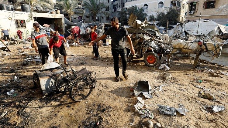 Palestinians inspect the site of an overnight Israeli strike on a tent, in Gaza City