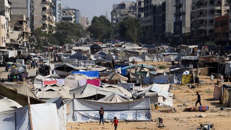 Displaced Palestinians take shelter in a tent camp, in Gaza City