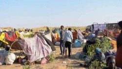 Displaced Sudanese gather and sit in makeshift tents after fleeing Al-Fashir city in Darfur