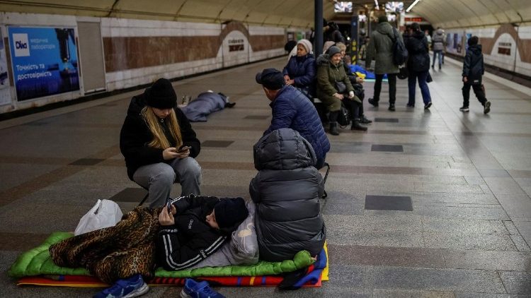 Pessoas se abrigam dentro de uma estação de metrô durante um ataque russo com mísseis e drones.