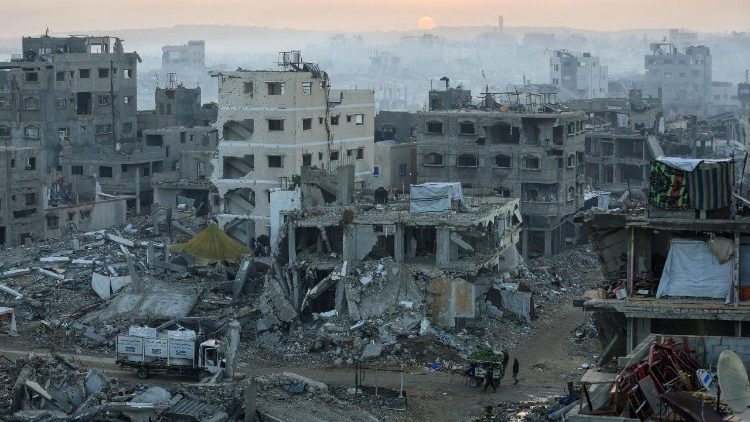 Palestinians walk past the rubble of destroyed buildings, in Gaza City