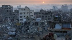 Palestinians walk past the rubble of destroyed buildings, in Gaza City